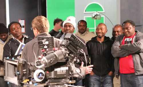 Nigerian filmmakers listen to Community College of Aurora adjunct instructor Tony Pfau, who instructs the group on how to economically move the camera in order to frame an intended shot.