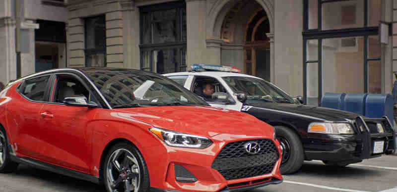 In the Hyundai ad, “Stoplight Standoff,” two police officers and a Veloster driver exchange in a very awkward standoff.