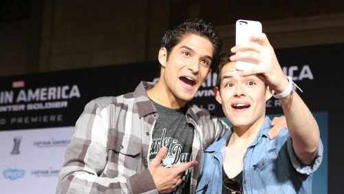 Celebrity host Tyler Posey and a Captain America fan pose for a selfie at Marvel's Captain America: The Winter Soldier surprise "for fans only" red carpet event.