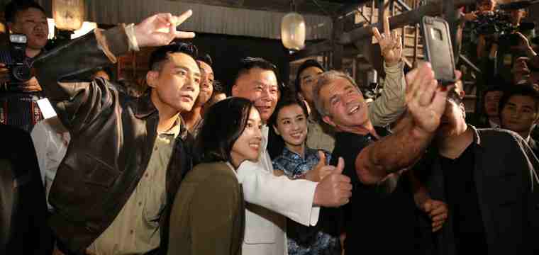 Dr. Shi Jianxiang and Mel Gibson taking a selfie at the conference with Chinese actor Liu Ye and other cast members